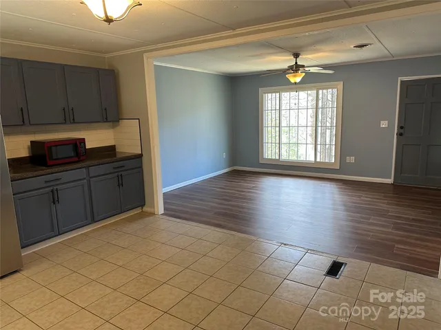a view of a kitchen with wooden floor and cabinets