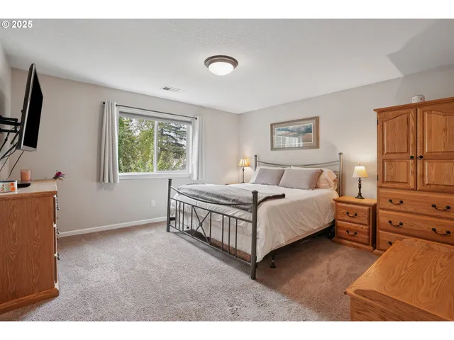 a spacious bedroom with a bed and a flat screen tv