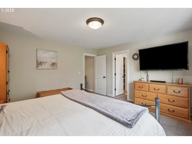 a bedroom with a bed and a flat screen tv