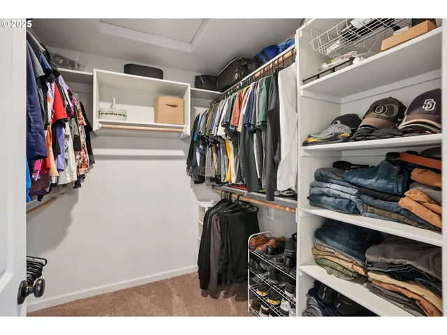 a view of walk in closet with clothes and shoes