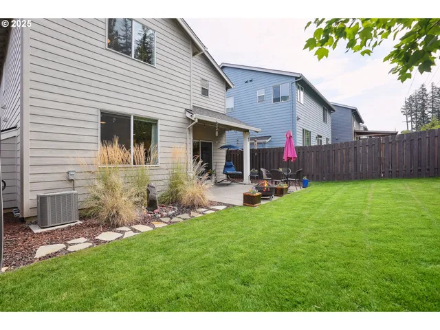 a view of a backyard with table and chairs potted plants and wooden fence