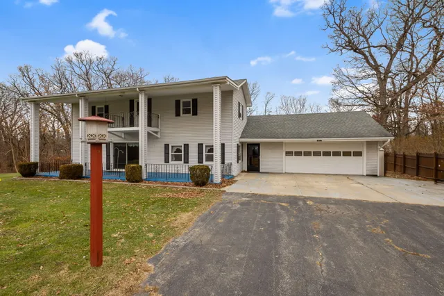 a view of a house with a big yard and large tree