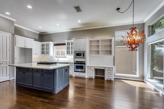 a kitchen with stainless steel appliances granite countertop a stove and a large window