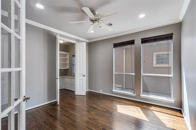 a view of an empty room with wooden floor fireplace and a window