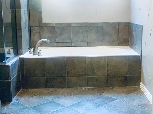 a bathroom with a bathtub and shower