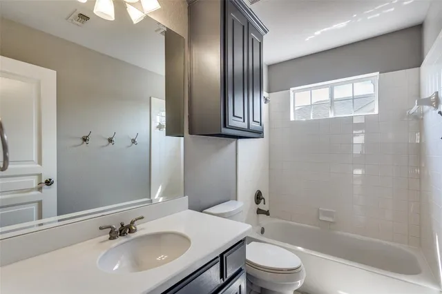 an empty room with wooden floor chandelier fan and windows