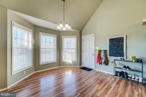 a view of house with yard and car parked