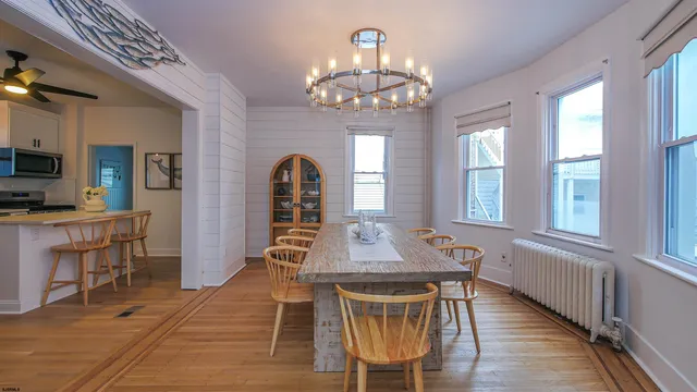 a view of a dining room with furniture a chandelier and wooden floor
