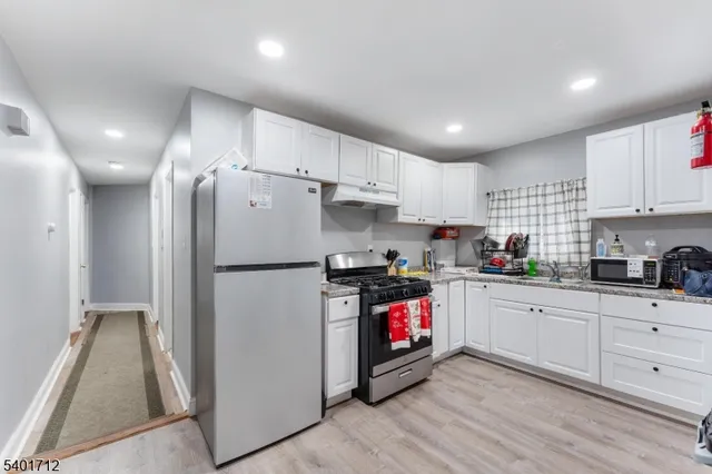 a kitchen with stainless steel appliances a stove a refrigerator a sink and cabinets