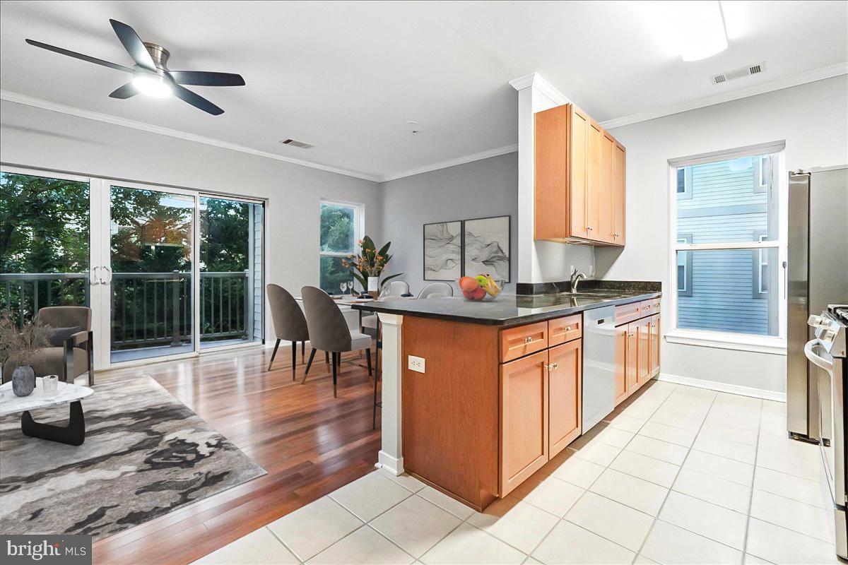 a kitchen with stainless steel appliances granite countertop a stove a sink a refrigerator and white cabinets with wooden floor