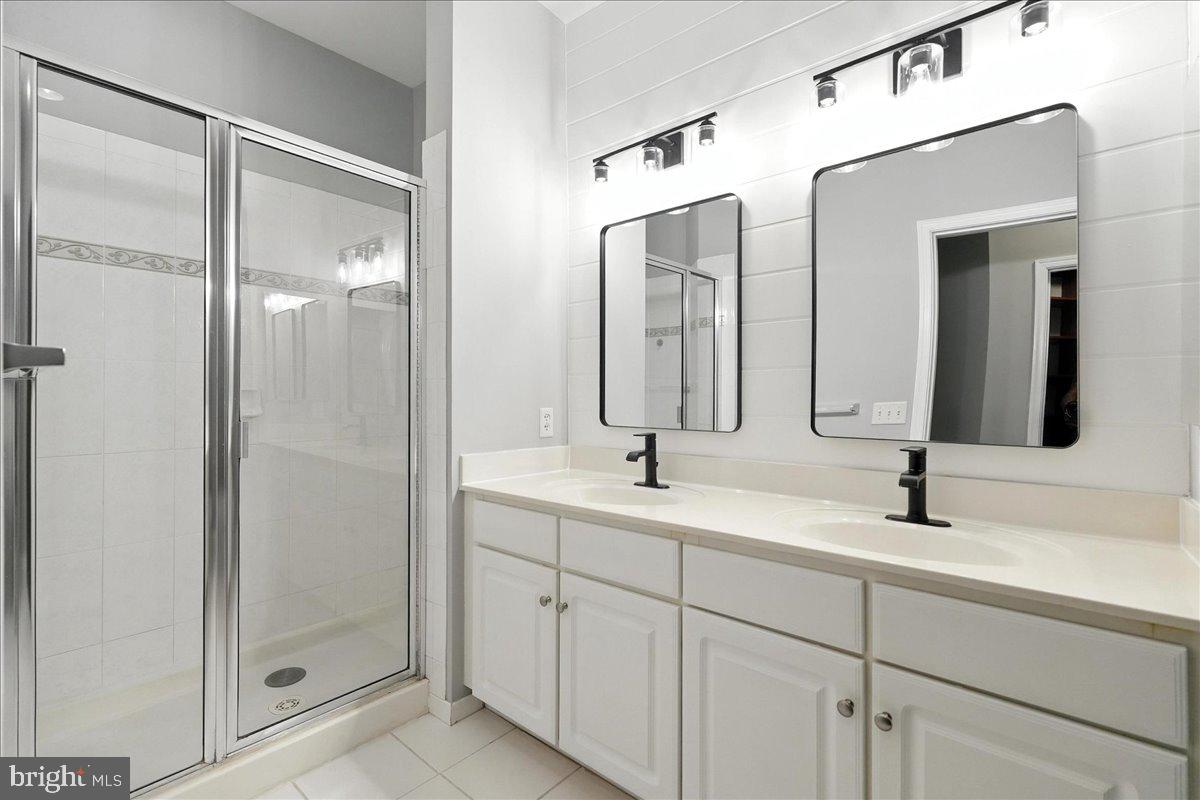 8045 Newell Street, Unit 301 Silver Spring, MD 20910 - Photo 13 of 19 a bathroom with a double vanity sink mirror and shower