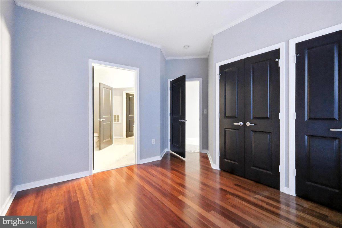 8045 Newell Street, Unit 301 Silver Spring, MD 20910 - Photo 14 of 19 a view of a hallway with wooden floor and a bathroom