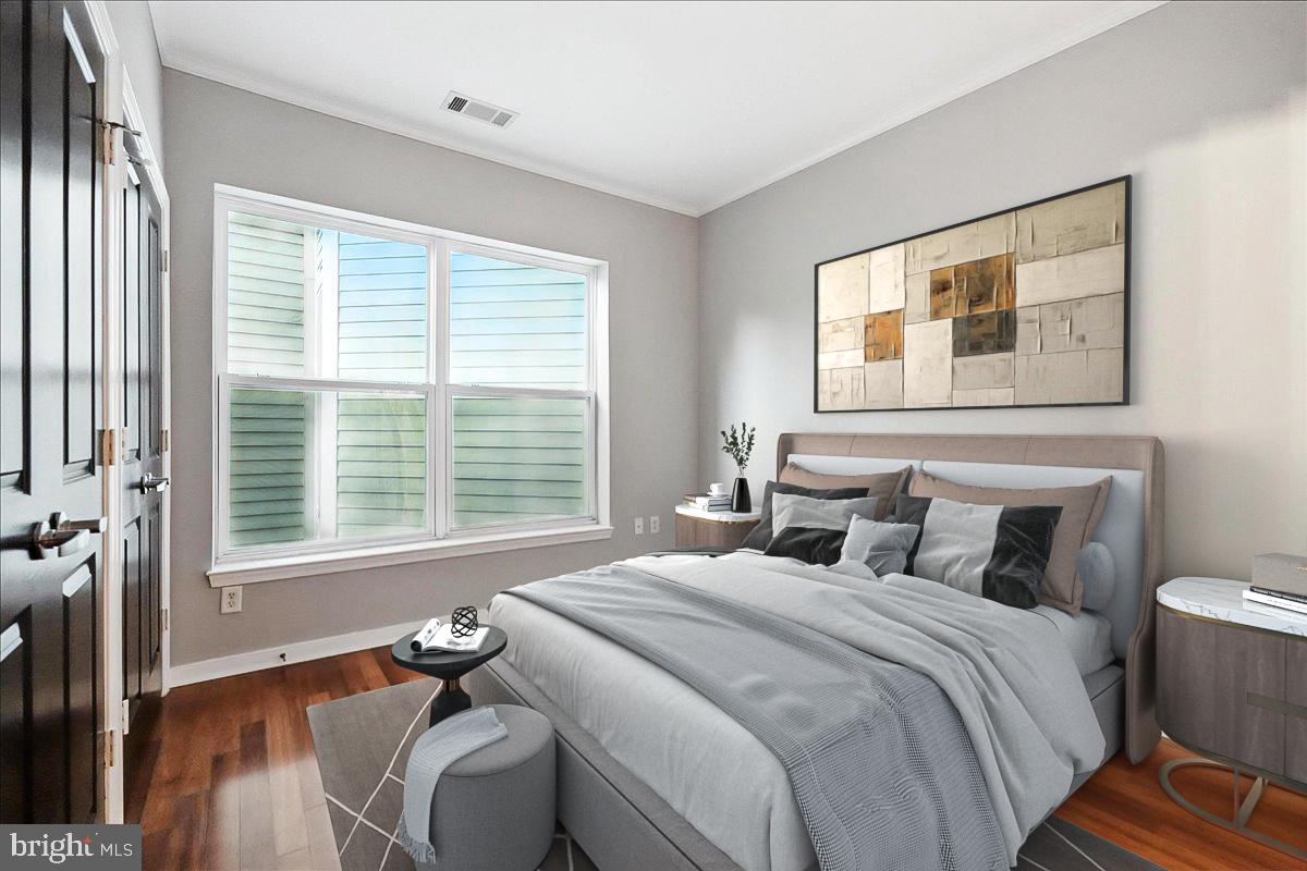 8045 Newell Street, Unit 301 Silver Spring, MD 20910 - Photo 7 of 19 a bedroom with a bed and wooden floor