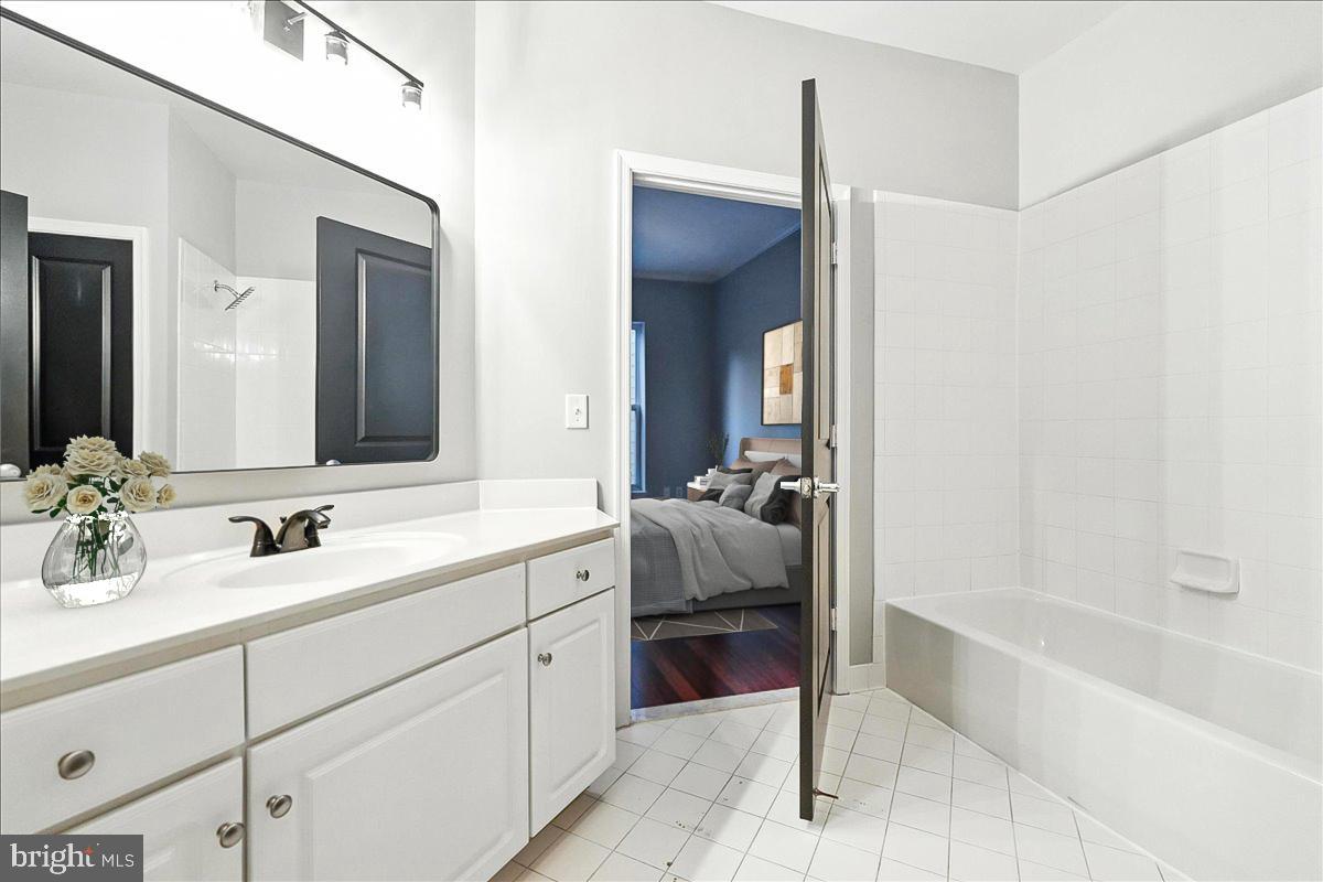 8045 Newell Street, Unit 301 Silver Spring, MD 20910 - Photo 8 of 19 a en suite bathroom with a double vanity sink tub and mirror