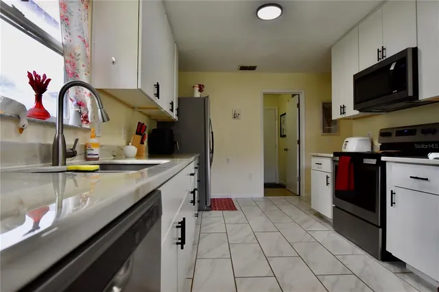 a kitchen with a sink cabinets and appliances