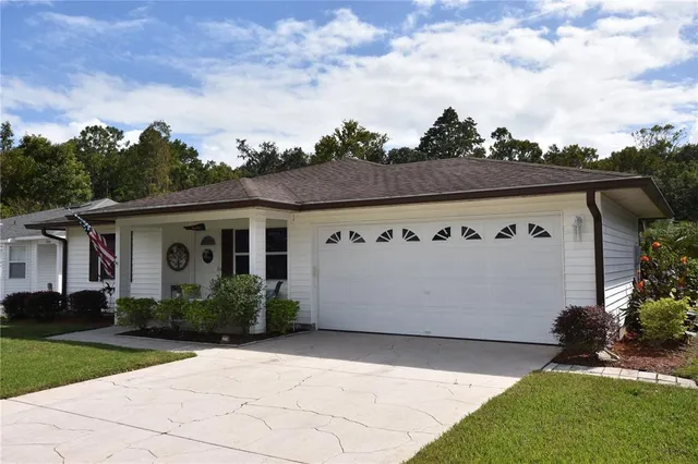a front view of house with yard and trees in the background
