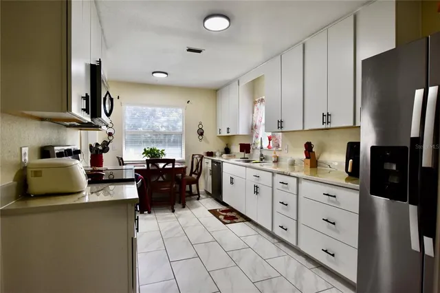 a kitchen with stainless steel appliances granite countertop a refrigerator sink and cabinets