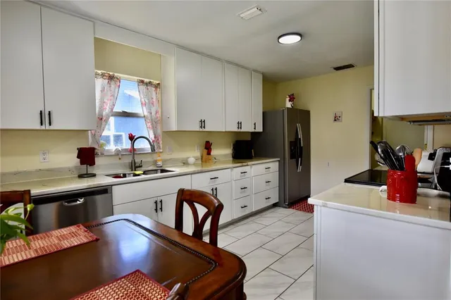 a kitchen with stainless steel appliances granite countertop a refrigerator sink and cabinets
