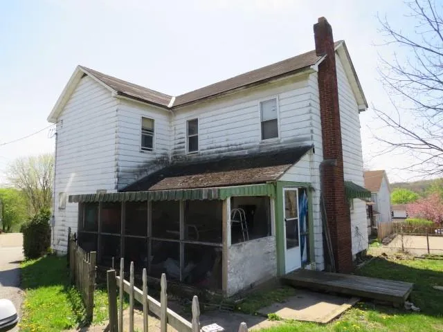 a view of brick house with a small yard and plants