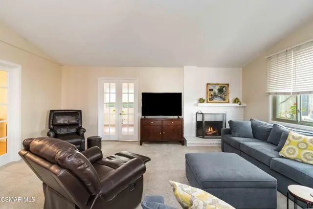 a living room with furniture a flat screen tv and a window