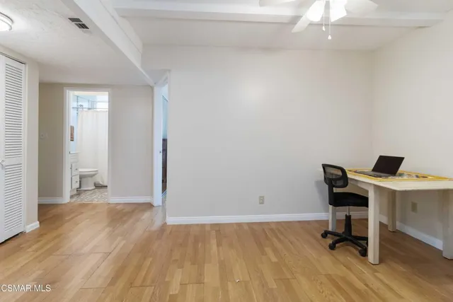 a view of a workspace with furniture and wooden floor