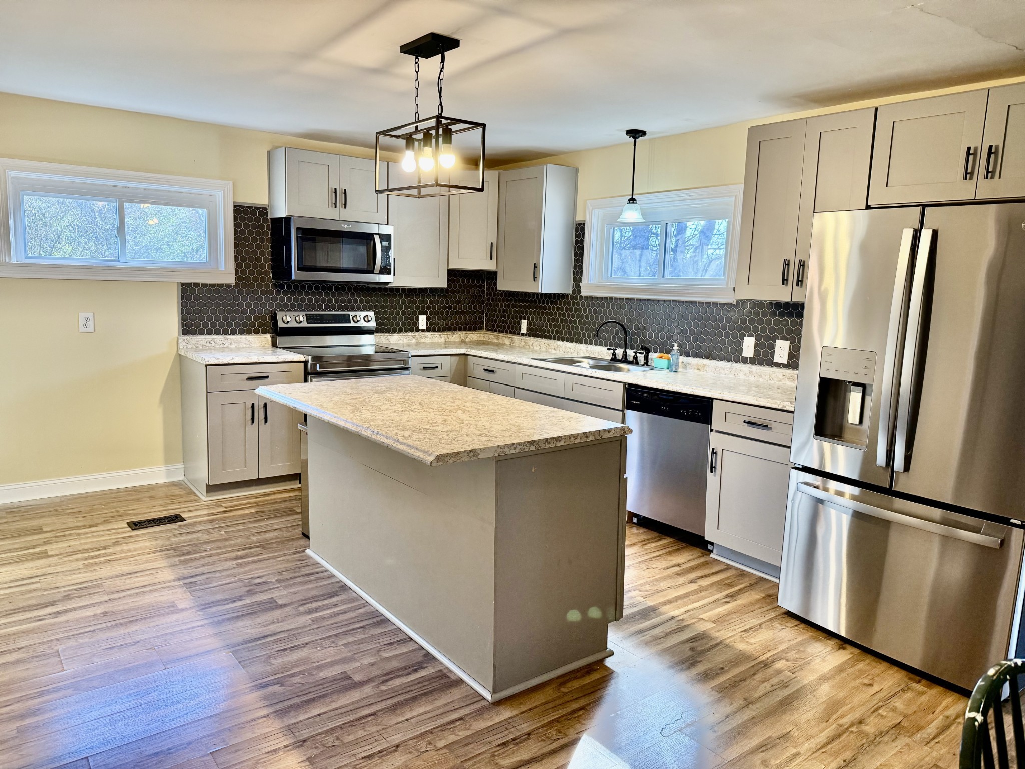1499 North Liberty Church Road Clarksville, TN 37042 - Photo 3 of 9 a kitchen with stainless steel appliances a stove top oven a refrigerator a sink and dishwasher with wooden floor