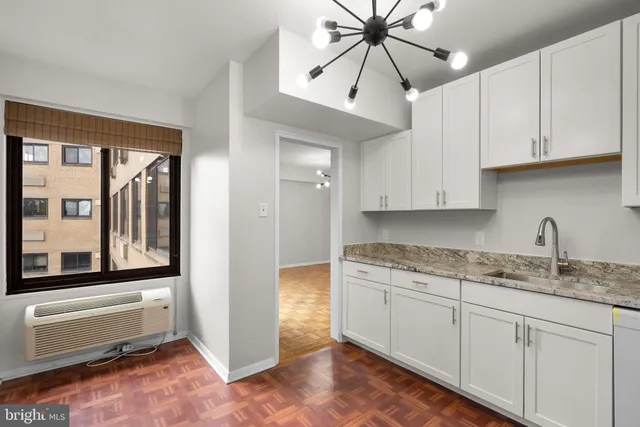 a kitchen with granite countertop white cabinets and white appliances