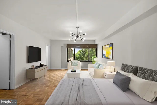 a living room with furniture a flat screen tv and a chandelier
