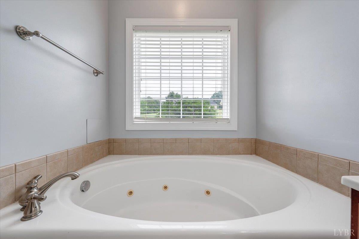 1250 Our Cove Road Huddleston, VA 24104 - Photo 24 of 70 a white bath tub sitting in a bathroom next to a window