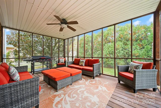 a living room with furniture a ceiling fan and a floor to ceiling window