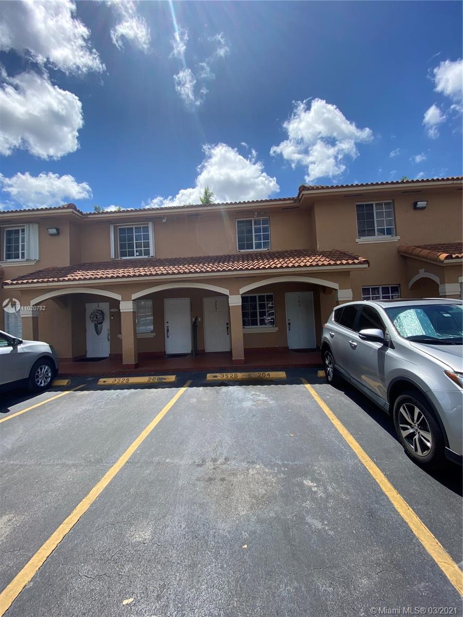 3526 West 76th Street, Unit 203 Hialeah, FL 33018 - Photo 1 of 30 a front view of a house with parking space and a ceiling fan