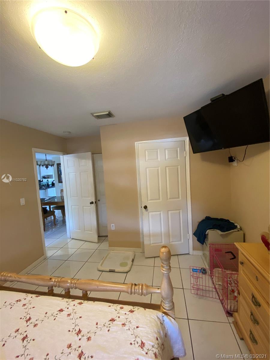 3526 West 76th Street, Unit 203 Hialeah, FL 33018 - Photo 19 of 30 a bedroom with a bed and a mirror