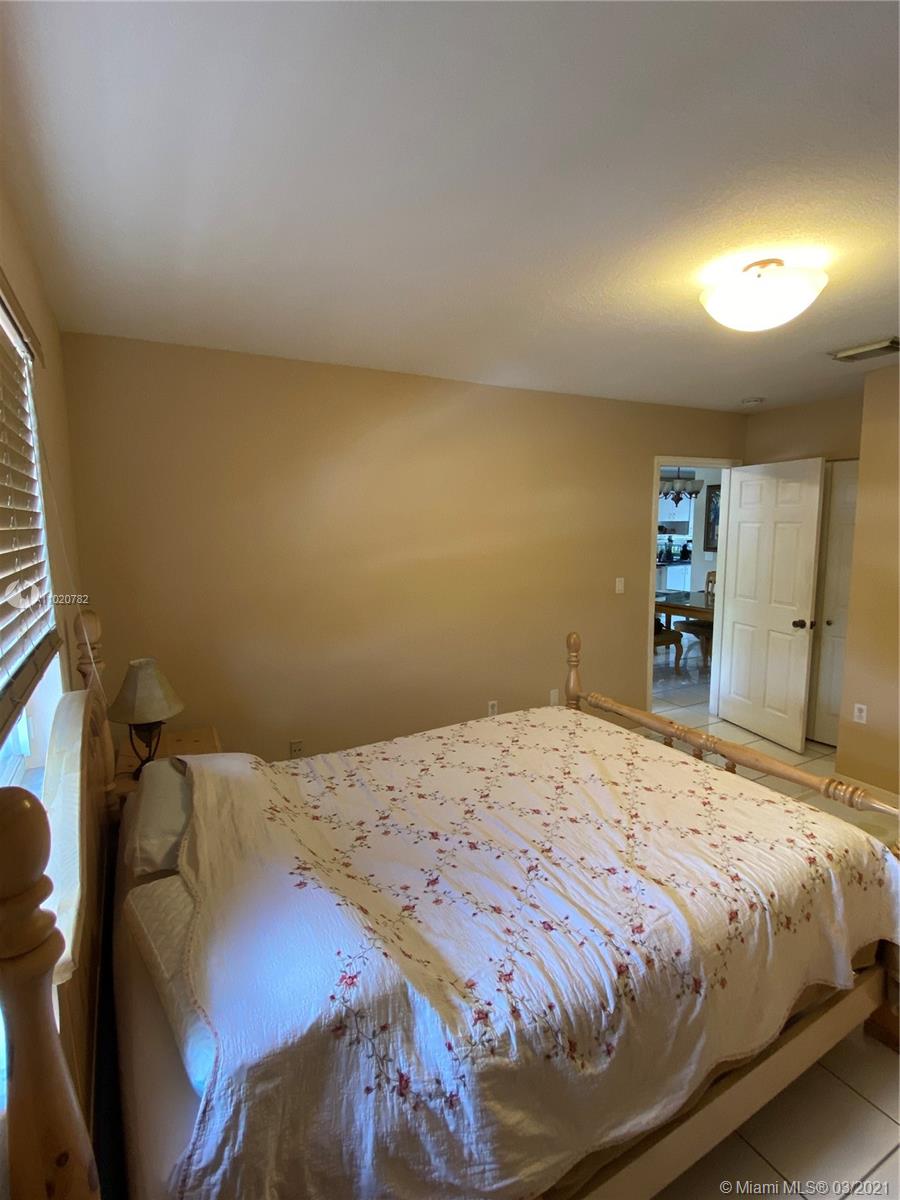3526 West 76th Street, Unit 203 Hialeah, FL 33018 - Photo 20 of 30 a bedroom with a bed and a large mirror