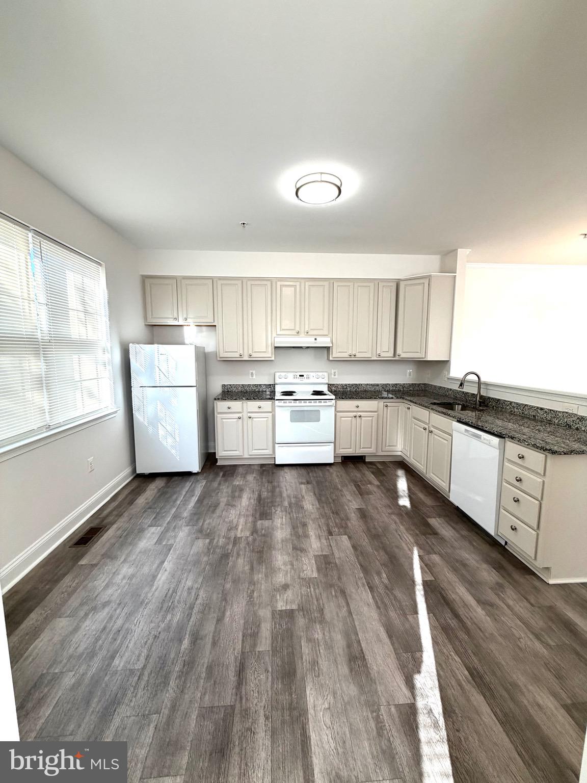 107 A Burck Street, Unit A Frederick, MD 21701 - Photo 11 of 22 a open kitchen with wooden floor and stainless steel appliances