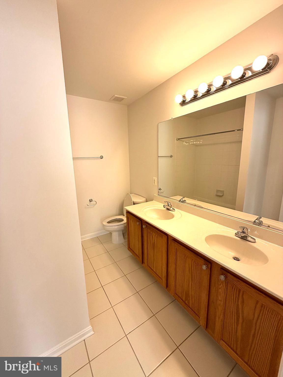 107 A Burck Street, Unit A Frederick, MD 21701 - Photo 15 of 22 a spacious bathroom with a double vanity sink and mirror