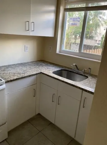 a kitchen with granite countertop a sink and a window
