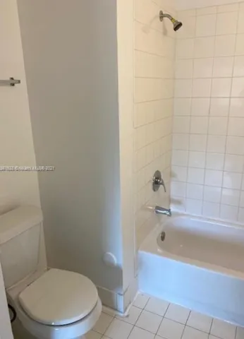 a white toilet sitting next to a bath tub