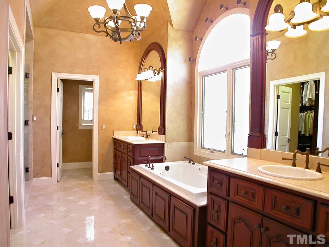 12200 Lockhart Lane Raleigh, NC 27614 - Photo 11 of 25 The lavish master bath breathes elegance and serenity. It shares luxurious marble walls, marble floors, frameless glass shower, custom cherry cabinets, vaulted ceilings and Durango honed limestone vanity counters.