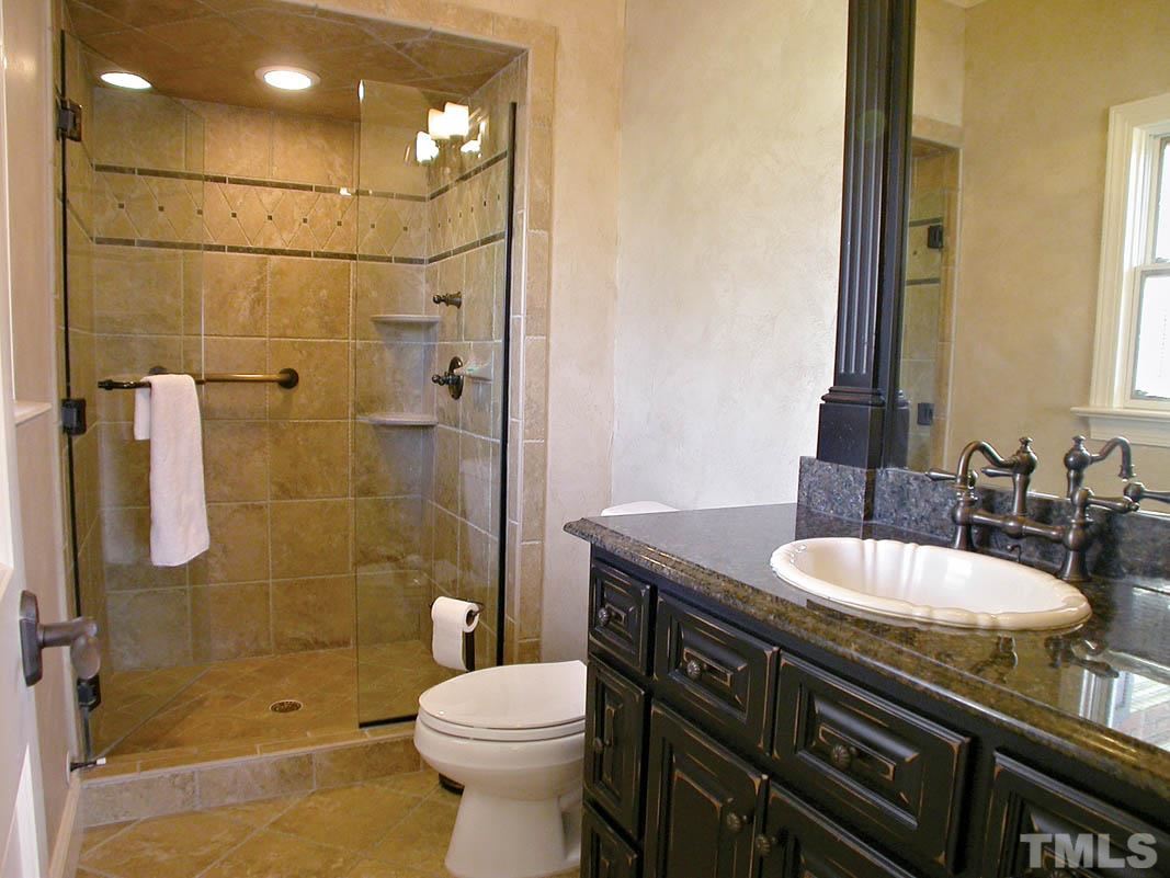 12200 Lockhart Lane Raleigh, NC 27614 - Photo 14 of 25 Private ensuite bath with custom black-glazed maple cabinets, granite countertops, porcelain tile floors and luxurious glass shower. A mini spa oasis for your guests!