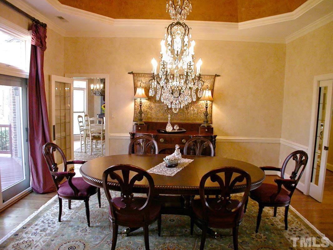 12200 Lockhart Lane Raleigh, NC 27614 - Photo 7 of 25 The exquisite formal dining room adorned with high ceilings, showcased by a magnificent Schoenbek crystal chandelier and rich French glass pocket doors has been designed for entertaining.