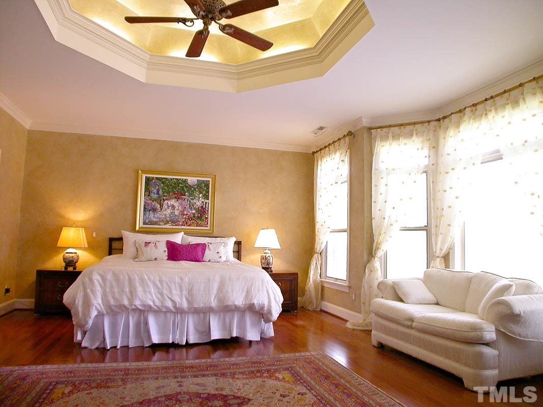 12200 Lockhart Lane Raleigh, NC 27614 - Photo 10 of 25 Stunning, light infused 1st floor master retreat embraces rosewood floors, large bay window, grand walk-in closet, cozy sitting area and sliding Pella doors opening to the spectacular outdoor deck.