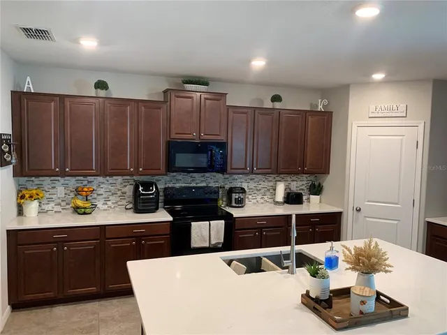 a kitchen with a refrigerator and a stove top oven