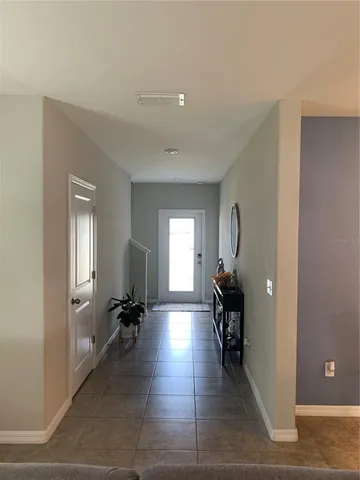 a view of a hallway with wooden floor and a living room