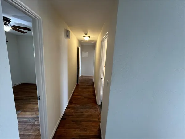 a view of a hallway with wooden floor and staircase