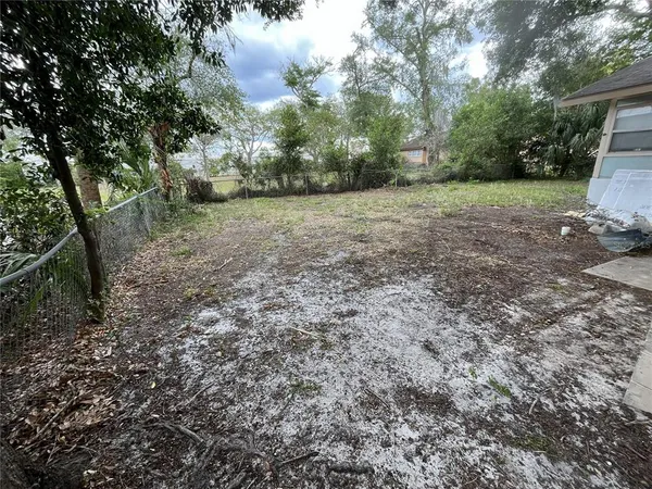 a view of a field with trees in the background