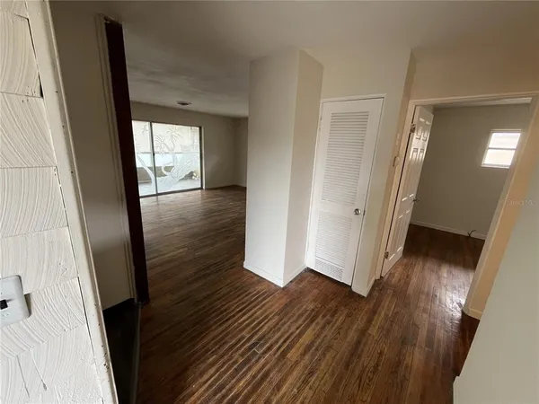 a view of a hallway with wooden floor and stairs