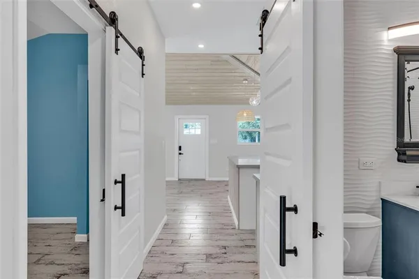 a view of a hallway with wooden floor and staircase