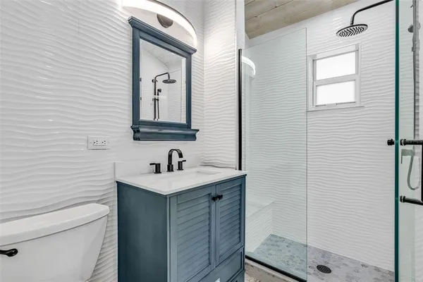 a bathroom with a sink a toilet and shower