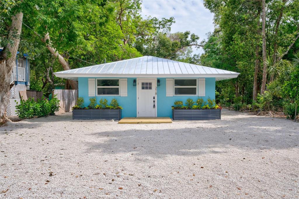 218 Lignumvitae Drive Key Largo, FL 33037 - Photo 2 of 35 a front view of a house with a garden