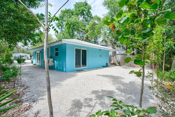 a view of a house with a yard and large tree